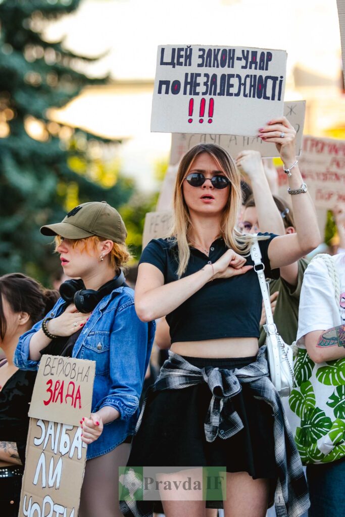 Люди тримають плакати на протесті в Україні.