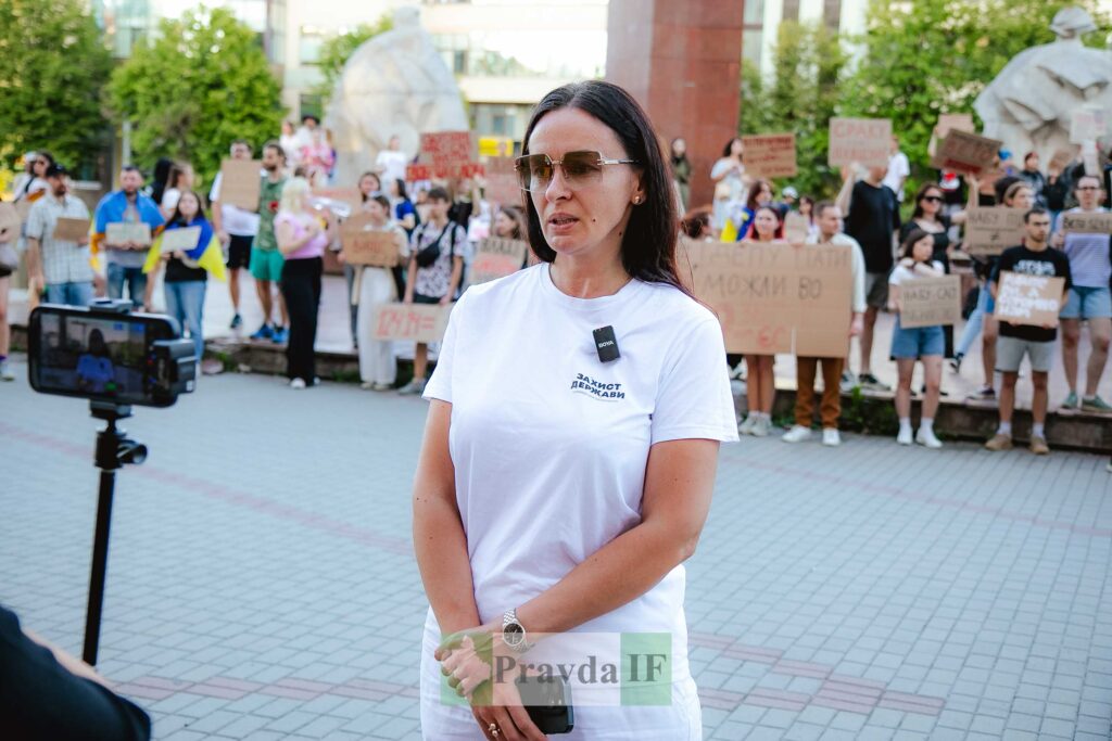 Жінка на мітингу, інтерв'ю на фоні протесту.