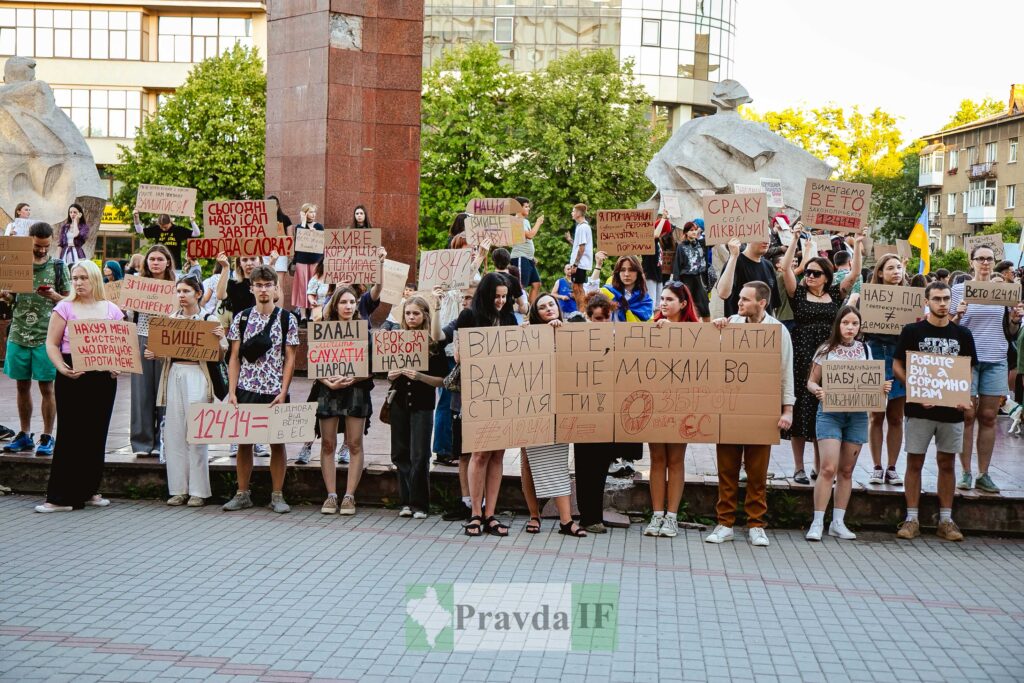 Люди на мітингу з плакатами в Україні.