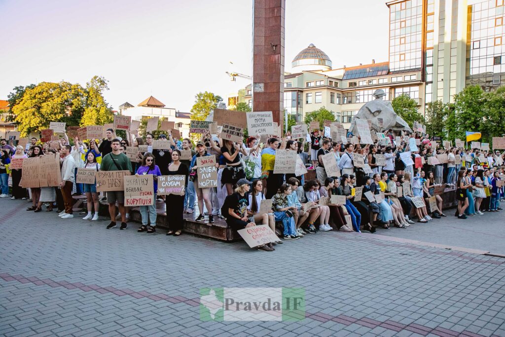 Люди на мітингу тримають плакати в Україні.
