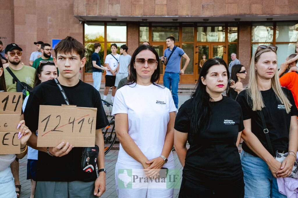 Люди на мітингу, тримають картонні плакати з числами.