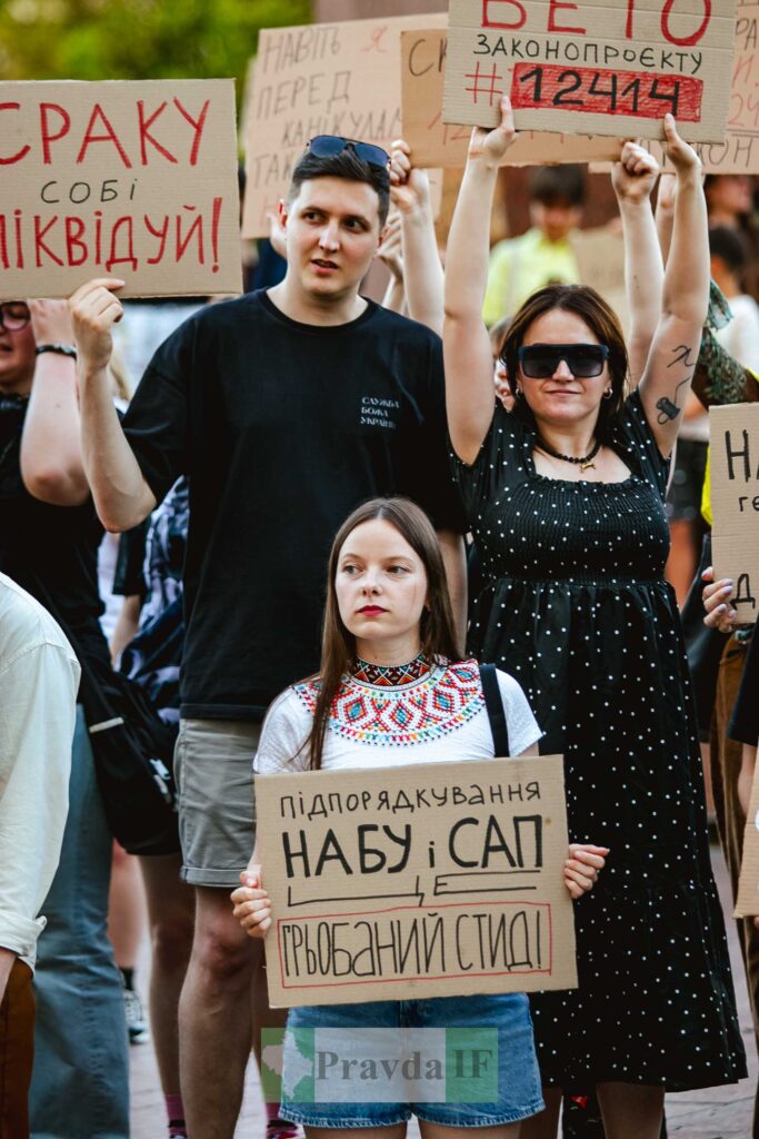 Протестувальники з плакатами на демонстрації в Україні.