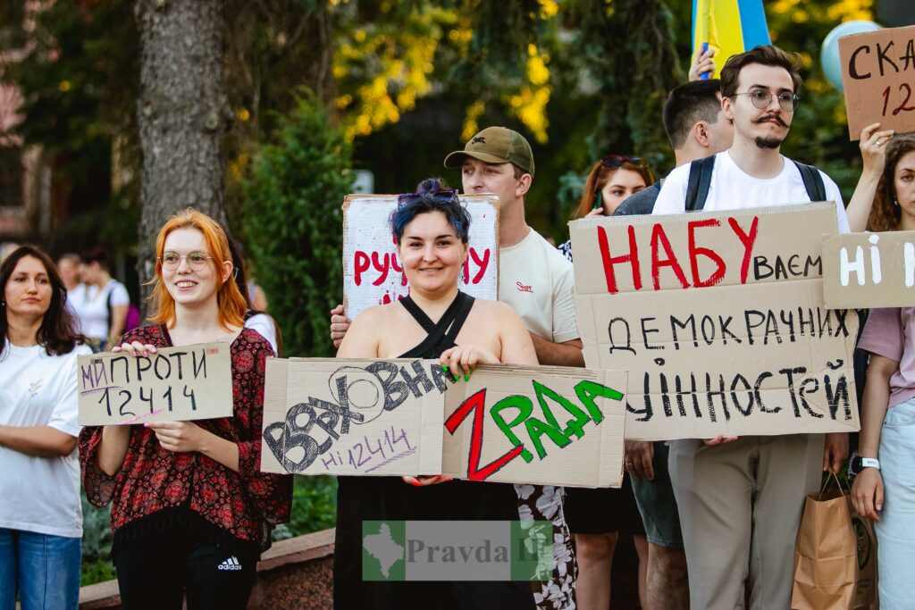Люди з плакатами на протесті в Україні.