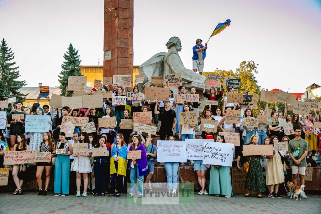 Протест в місті з плакатами і прапором України.