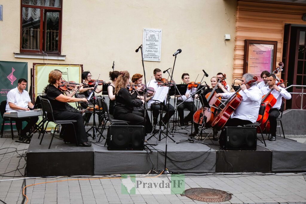 Вуличний концерт оркестру біля будівлі.