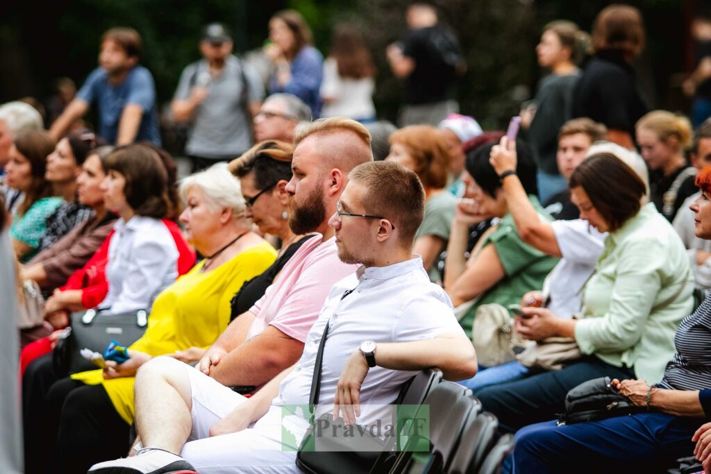 Люди на вуличному заході сидять у глядацькій зоні.