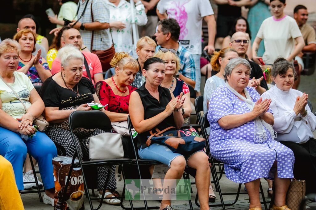 Група людей аплодує на вуличному заході.