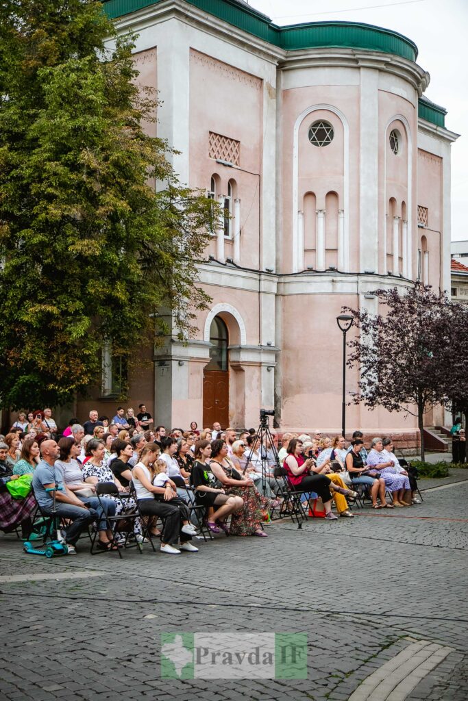 Група людей сидить біля старої будівлі