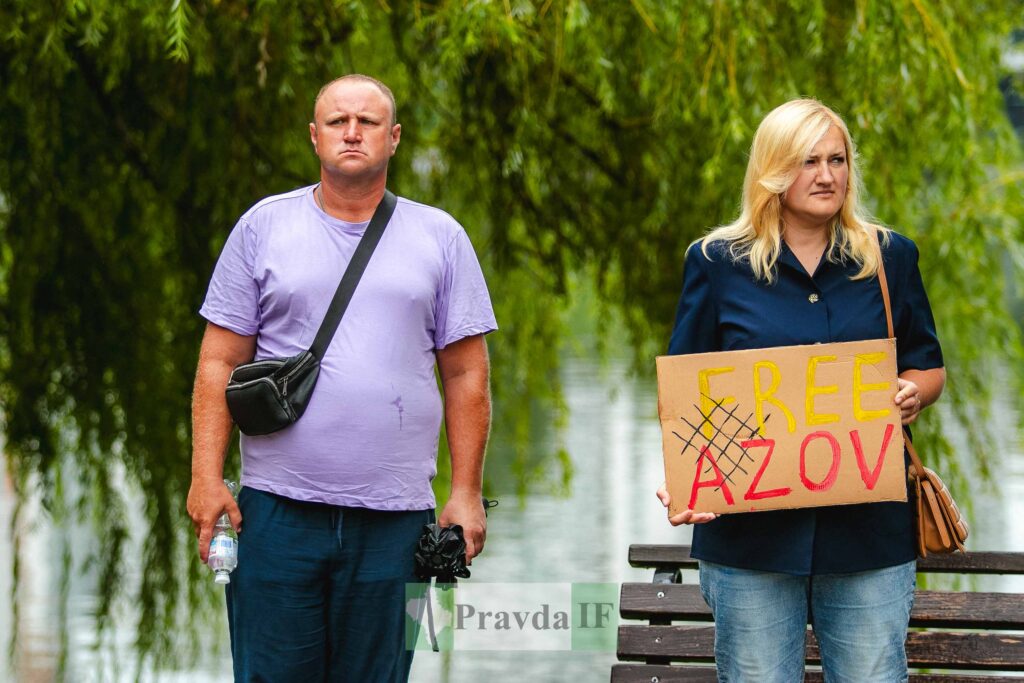 Чоловік і жінка тримають плакат 'Free Azov'.