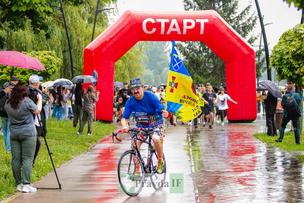 Захід з червоним стартовим аркою та велосипедистом