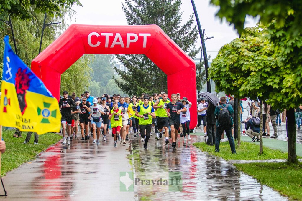 Старт марафону під дощем, учасники біжать доріжкою.