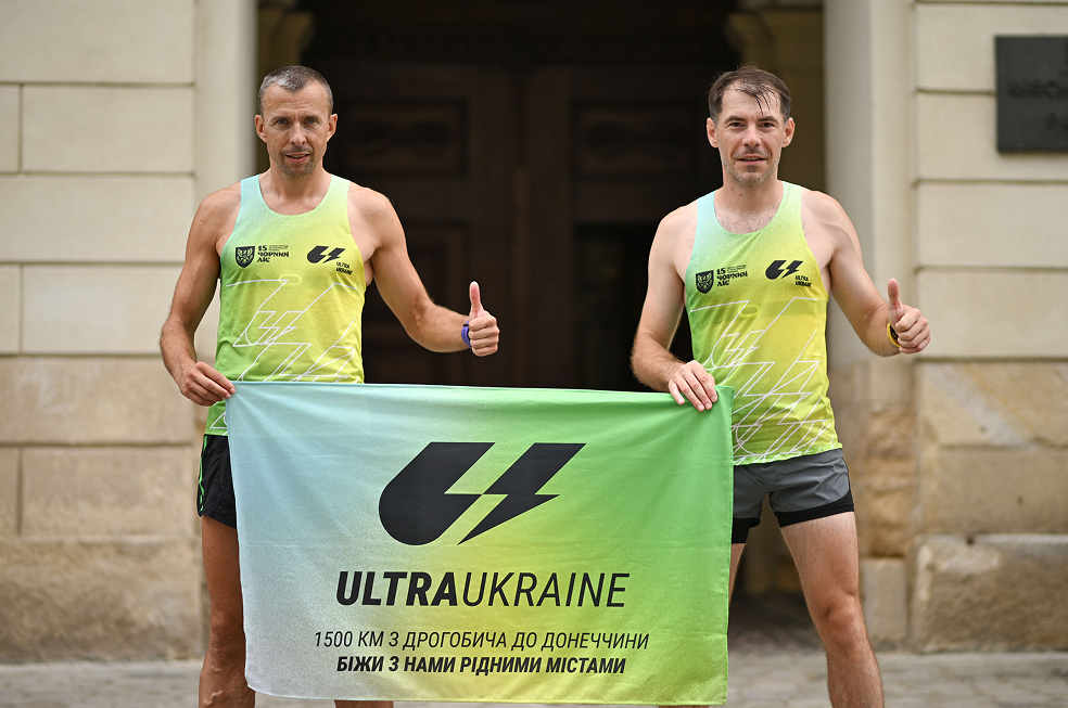 Двоє бігунів тримають прапор UltraUkraine.