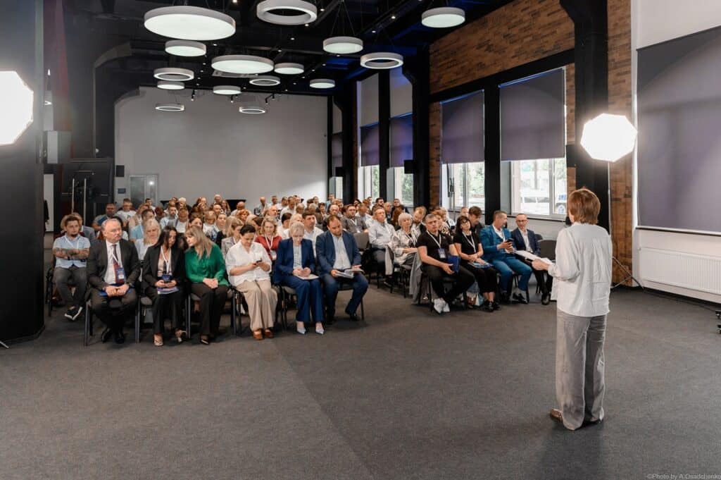 Люди слухають презентацію у залі конференцій.