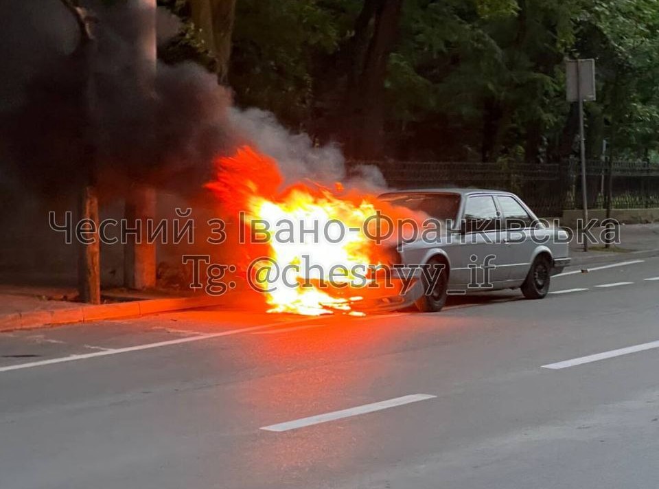 Автомобіль горить на дорозі, сильний дим.