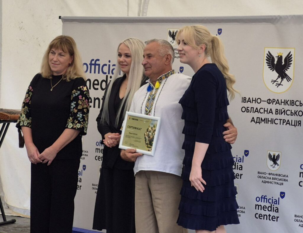 Група людей з сертифікатом на урочистій події.