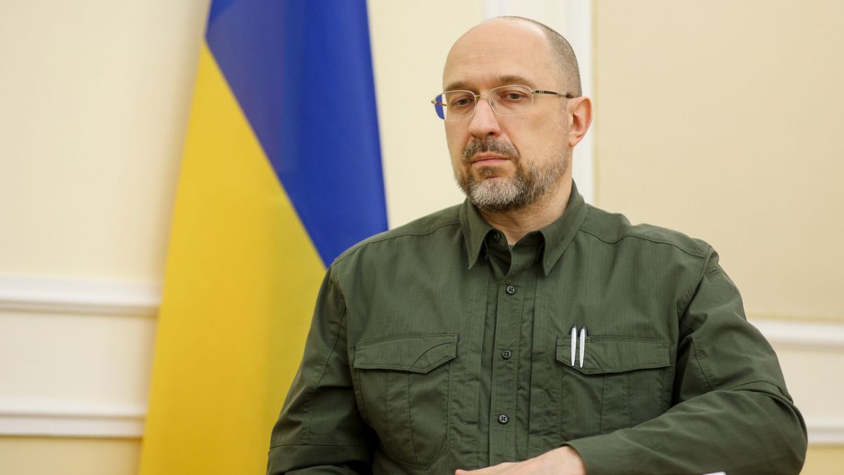 Чоловік на фоні прапора України в кабінеті.