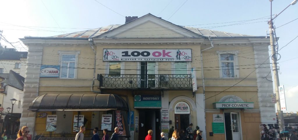 Старий будинок із вивісками магазинів у центрі.