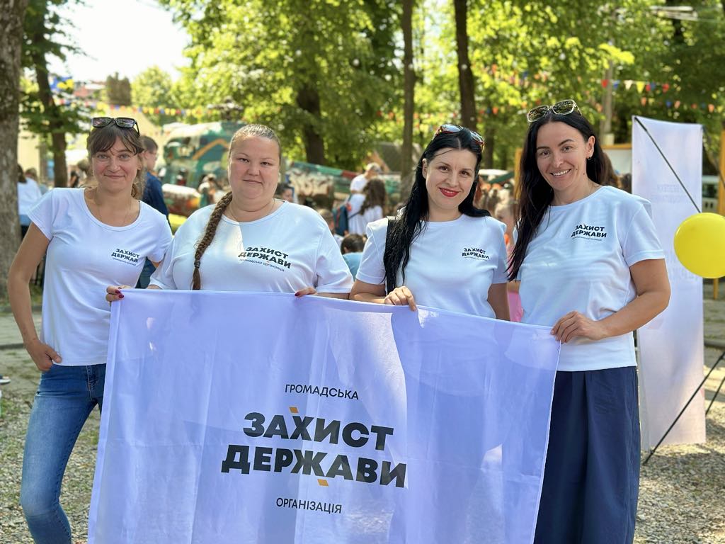 Чотири жінки тримають прапор на вулиці