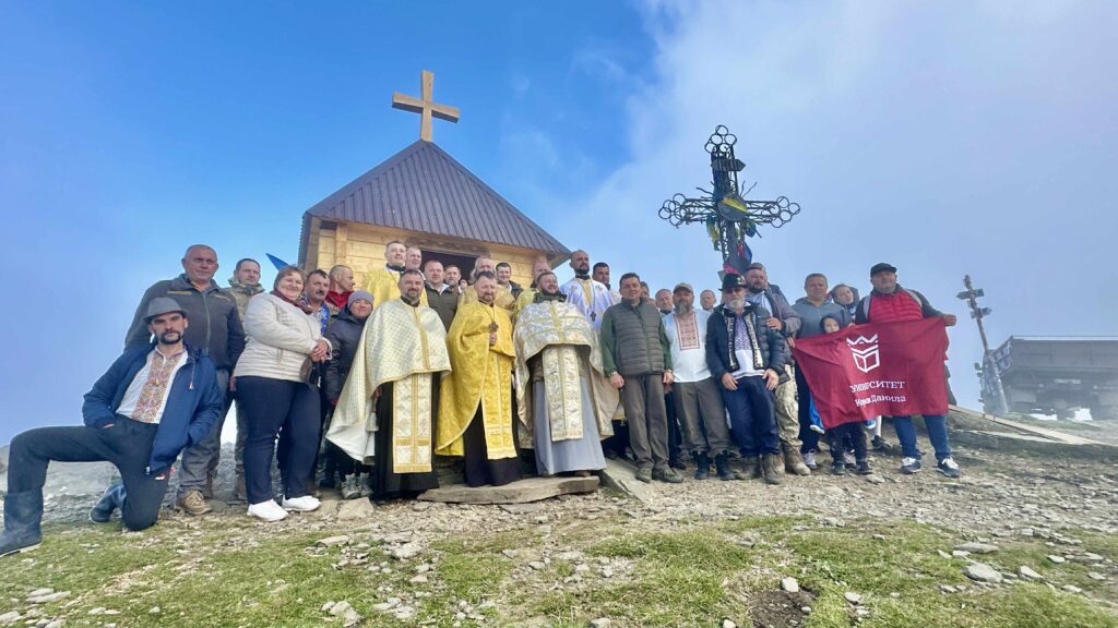 Група людей перед каплицею у горах