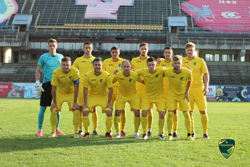 Футбольна команда у жовтій формі на полі