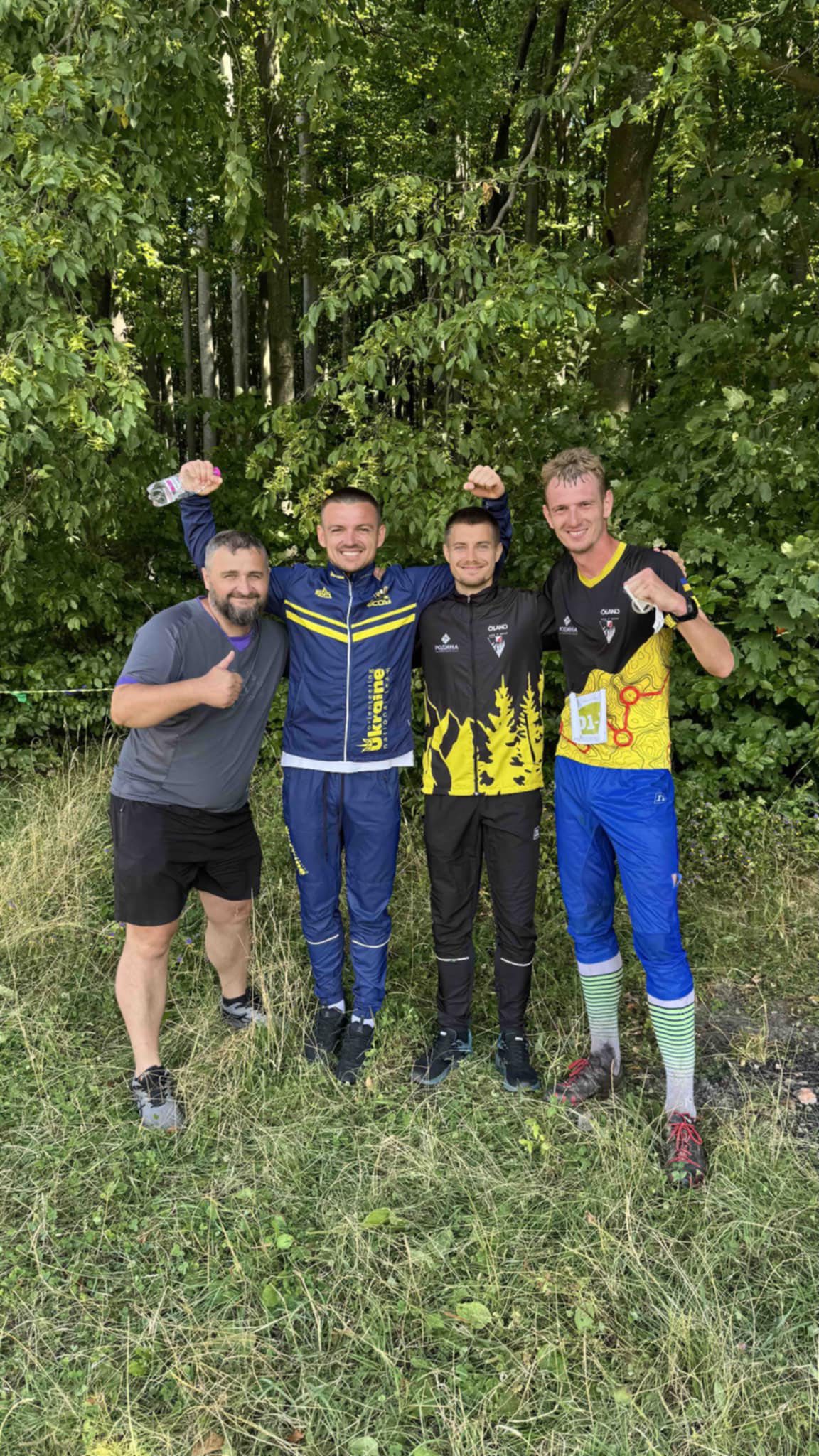 Четверо чоловіків у спортивному одязі на природі