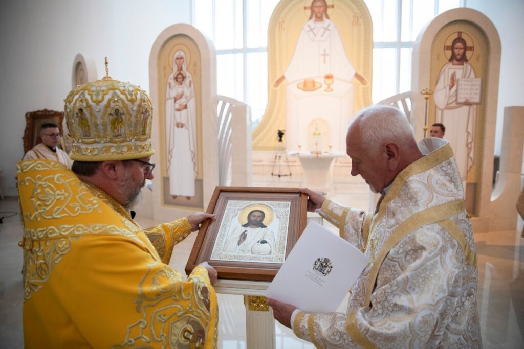 Священники з іконою в церкві