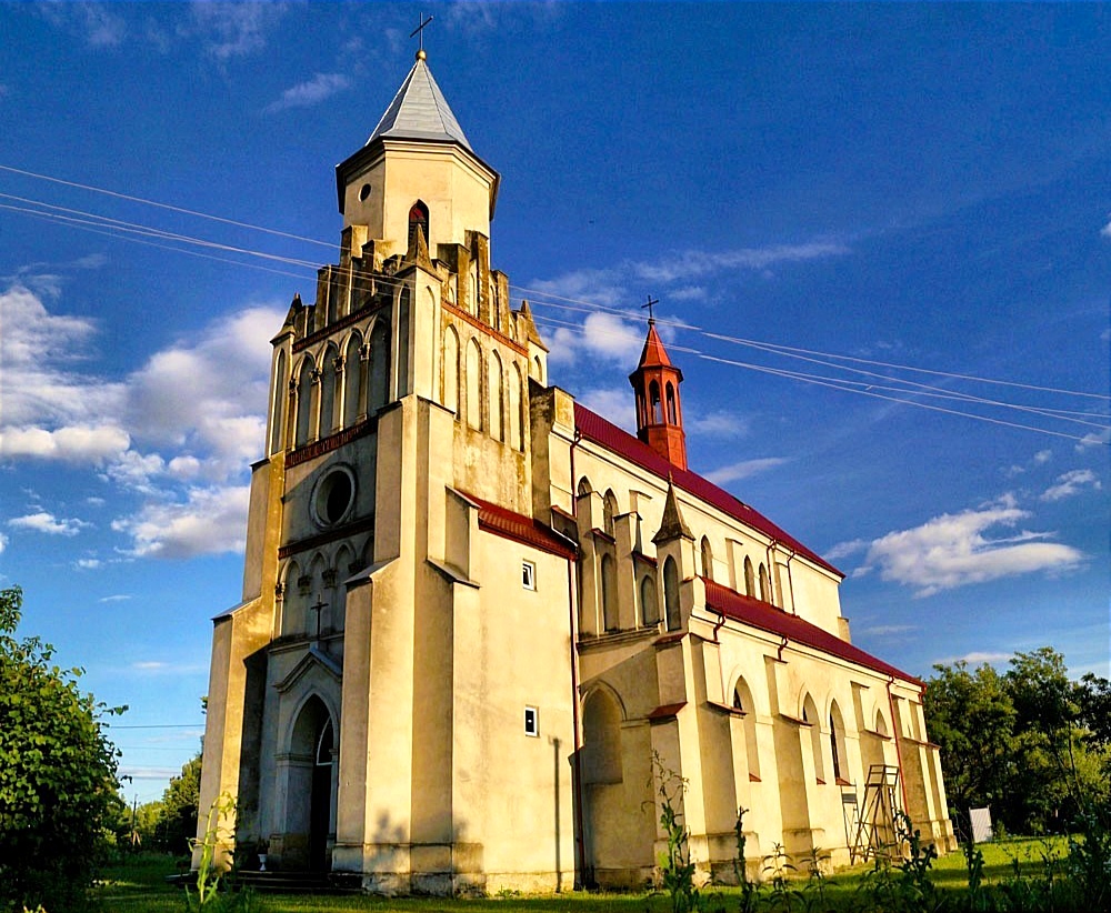 Старовинна біла церква на тлі блакитного неба.