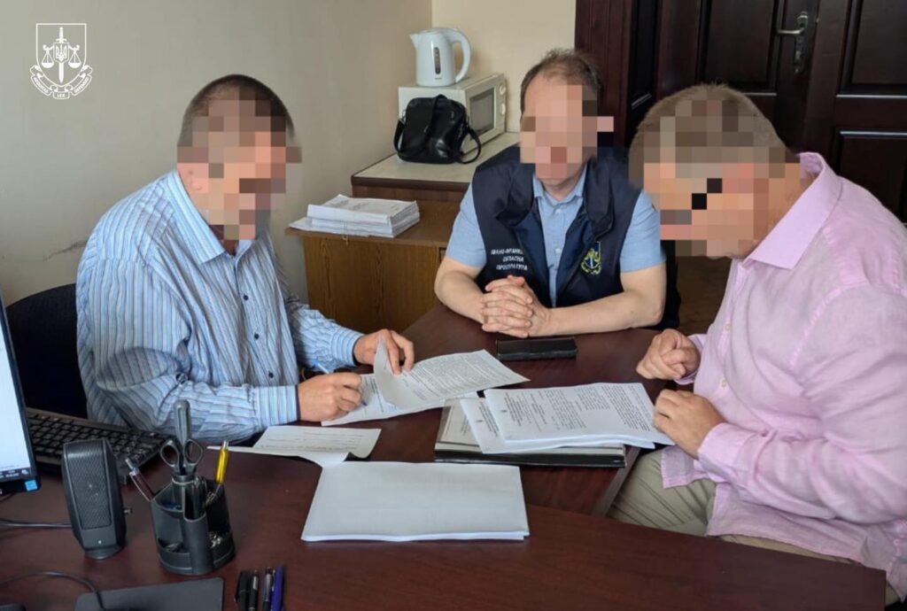 Троє чоловіків читають документи за столом в офісі.