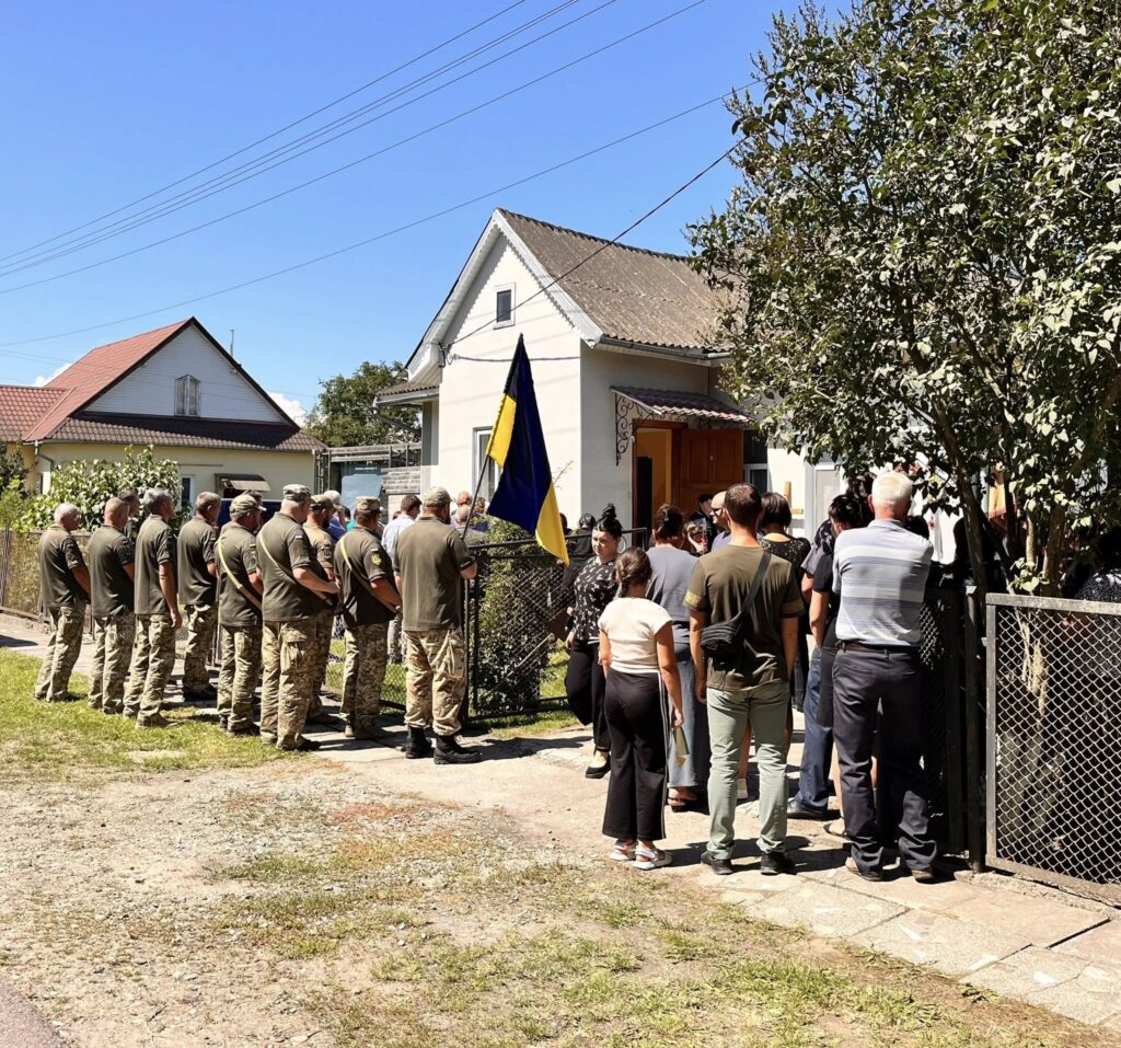 Люди на вулиці біля прапора України.