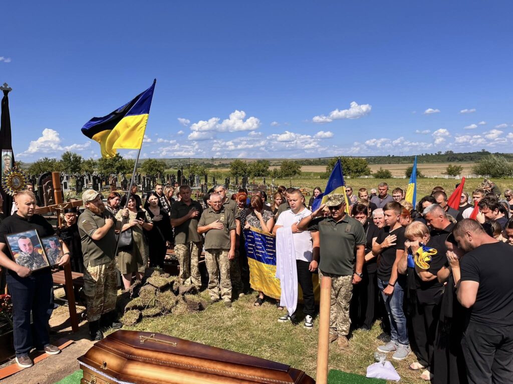 Поховання з українськими прапорами, люди прощаються.