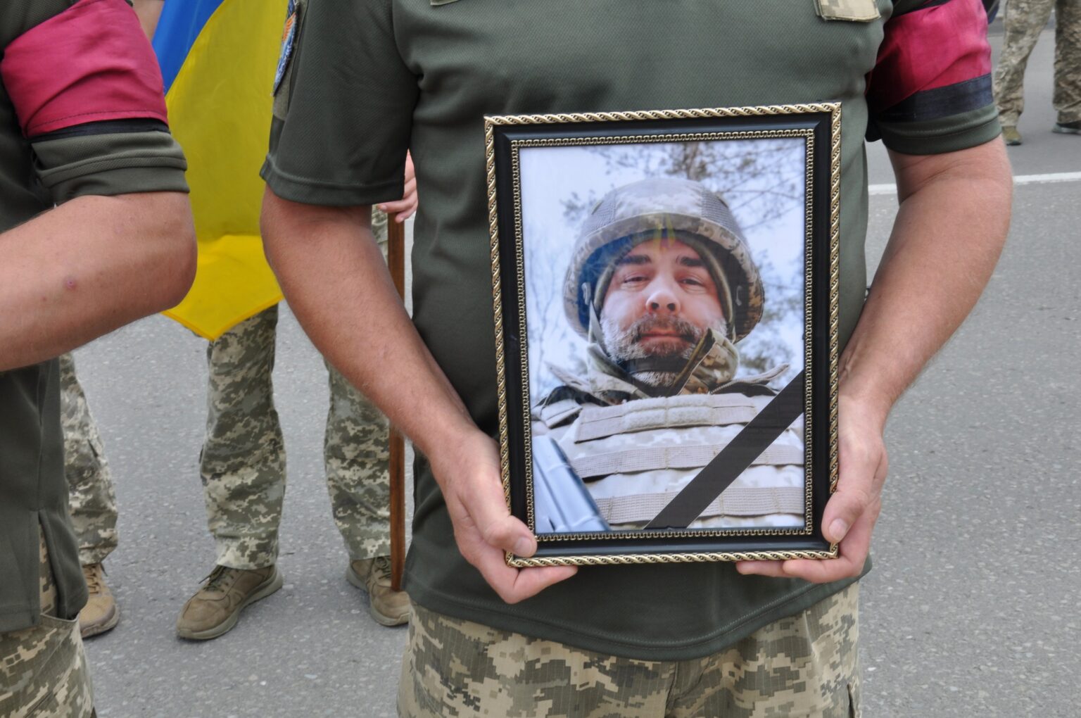 Воїн тримає фото загиблого побратима.