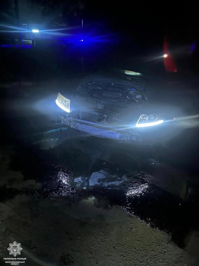 Пошкоджене авто вночі на мокрій дорозі