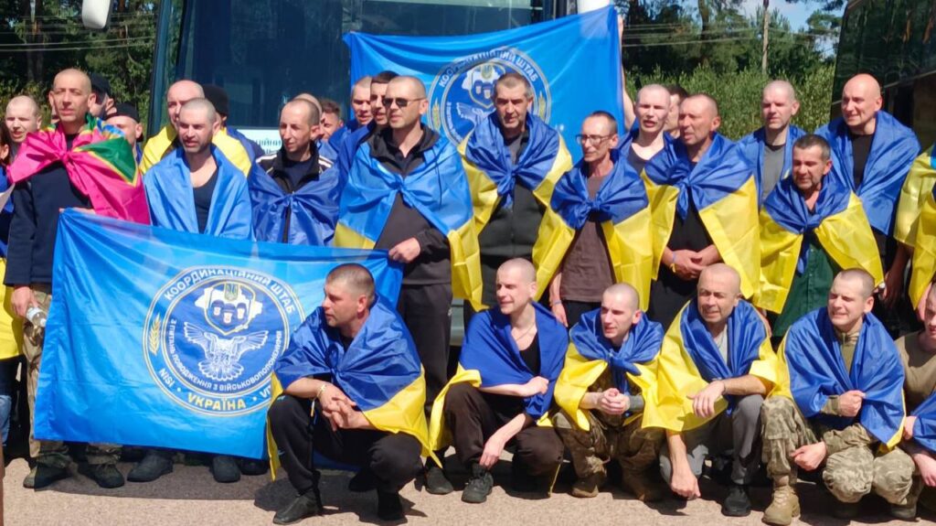 Група осіб з українськими прапорами на вулиці.