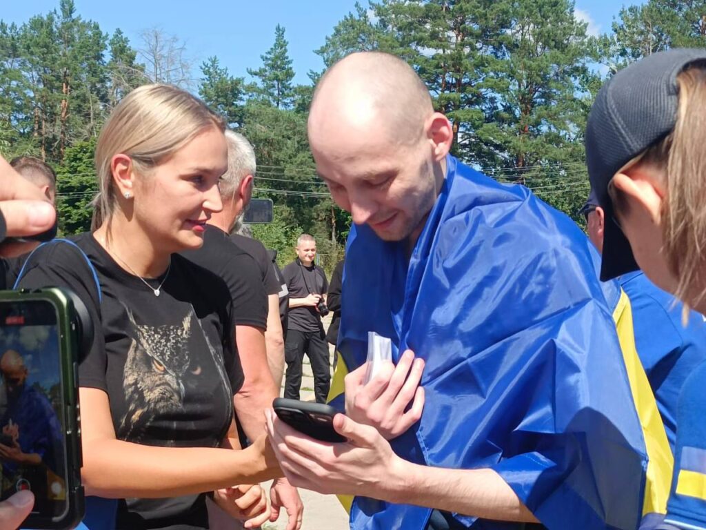 Люди на вулиці в українському прапорі спілкуються.
