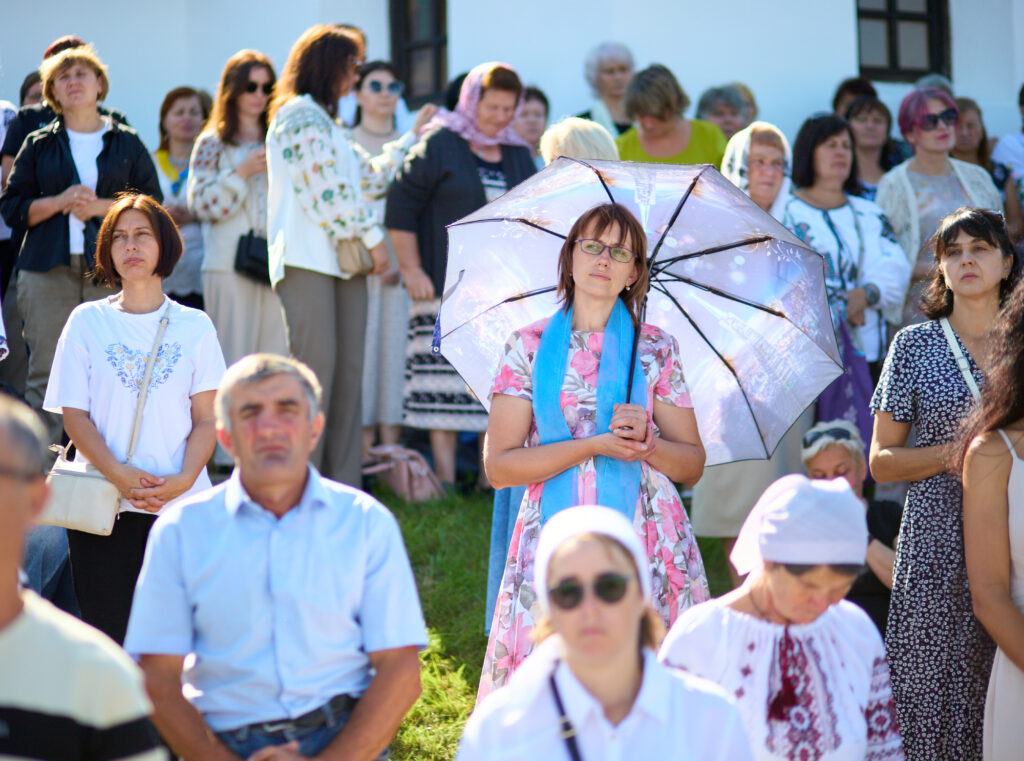Люди на вуличному заході з парасолькою.