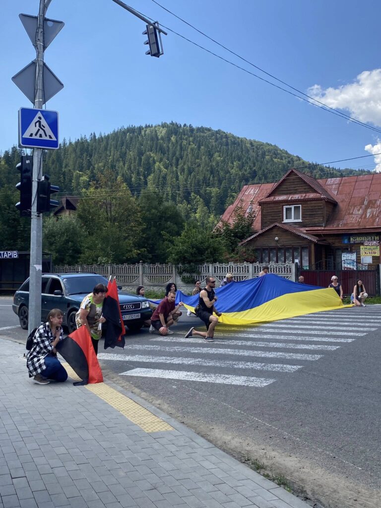 Люди на пішохідному переході з прапорами України