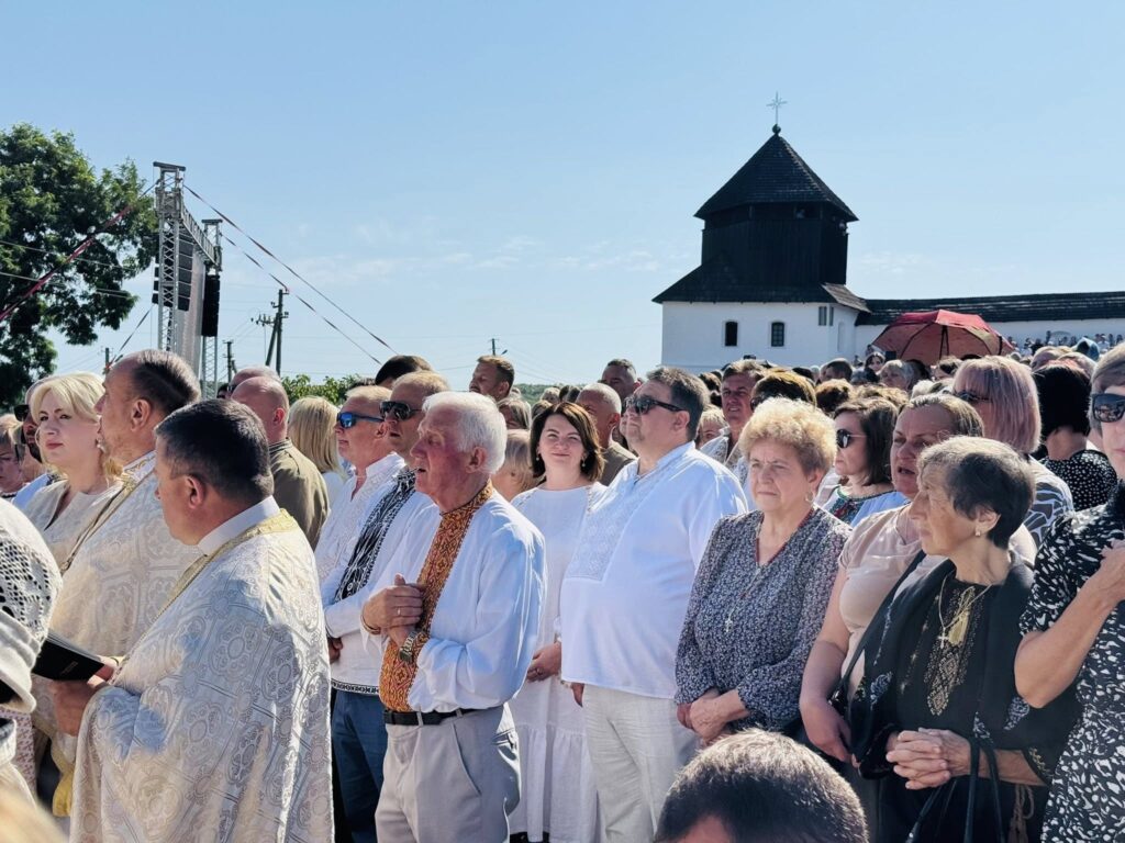 Люди на вуличному заході біля церкви.