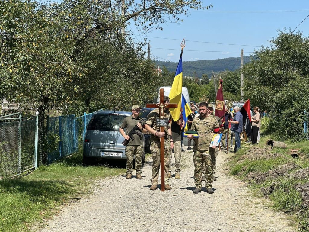 Процесія з прапорами і хрестом на вулиці