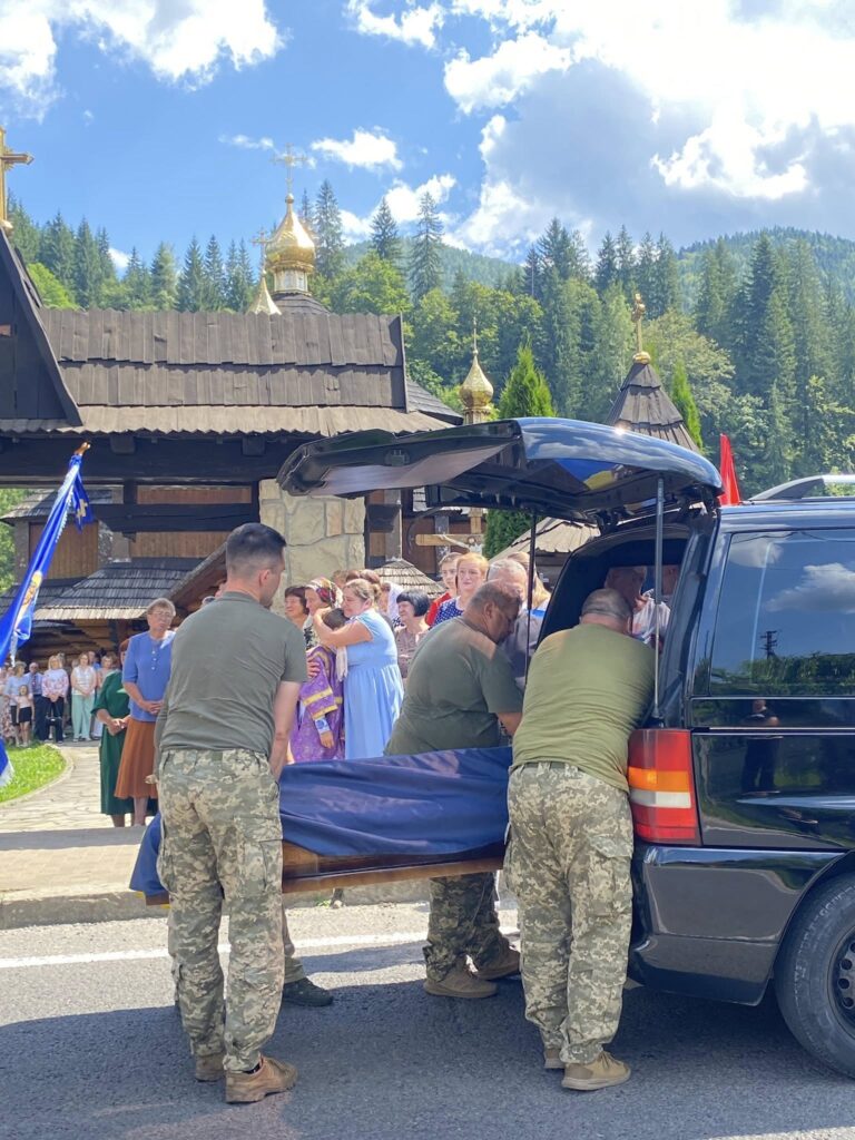 Військові несуть труну біля церкви на похороні.