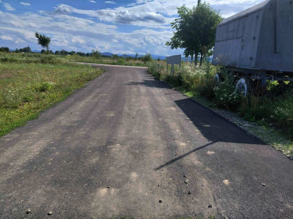 Асфальтована дорога на сільській місцевості, сонячна погода.