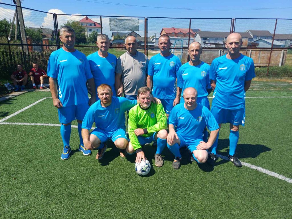 Команда футболістів на полі в синій формі.