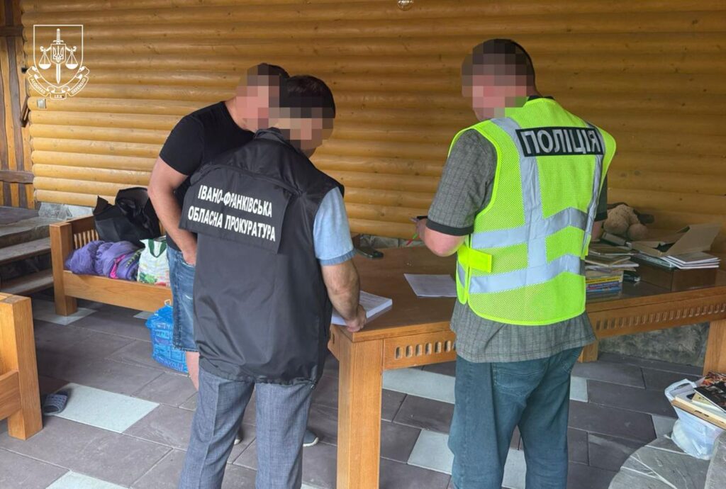 Поліція та прокуратура на огляді документів біля столу.