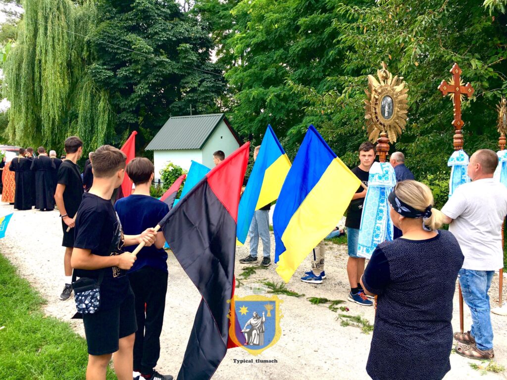 Люди з прапорами на релігійному заході