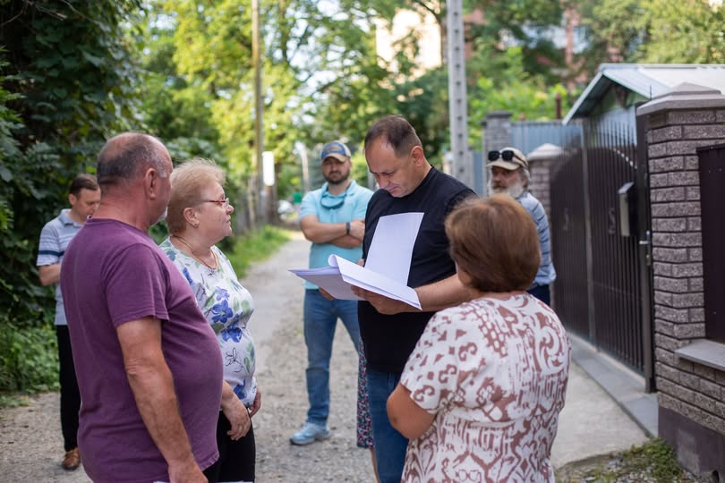 Група людей обговорює документи на вулиці