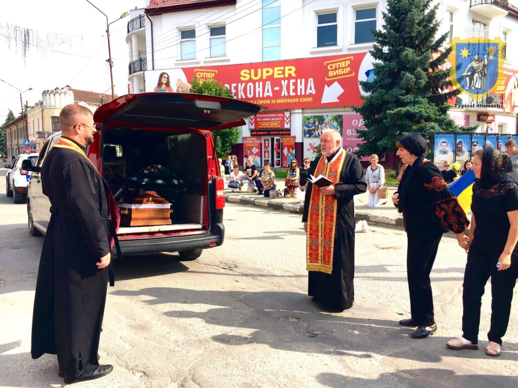 Похоронна процесія на вулиці міста.