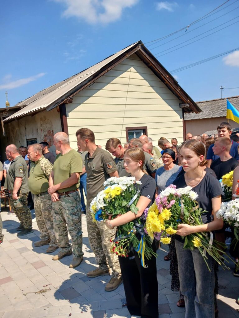 Люди вшанували пам'ять, тримаючи квіти біля будинку.