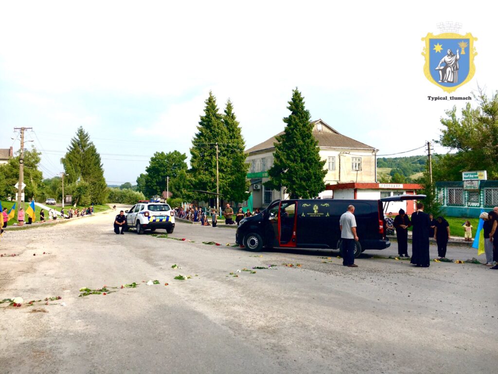 Похоронна процесія на вулиці з квітами