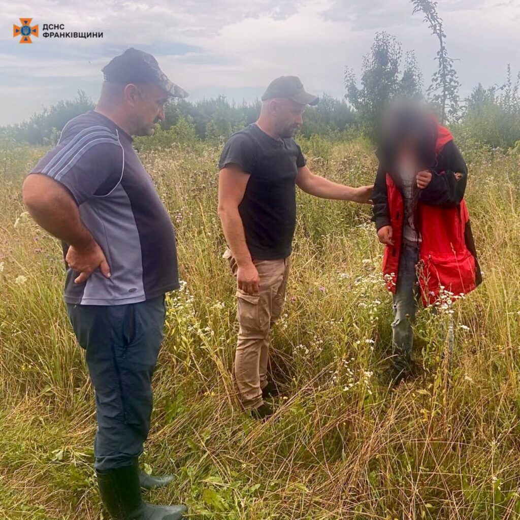 Двоє чоловіків допомагають людині в полі