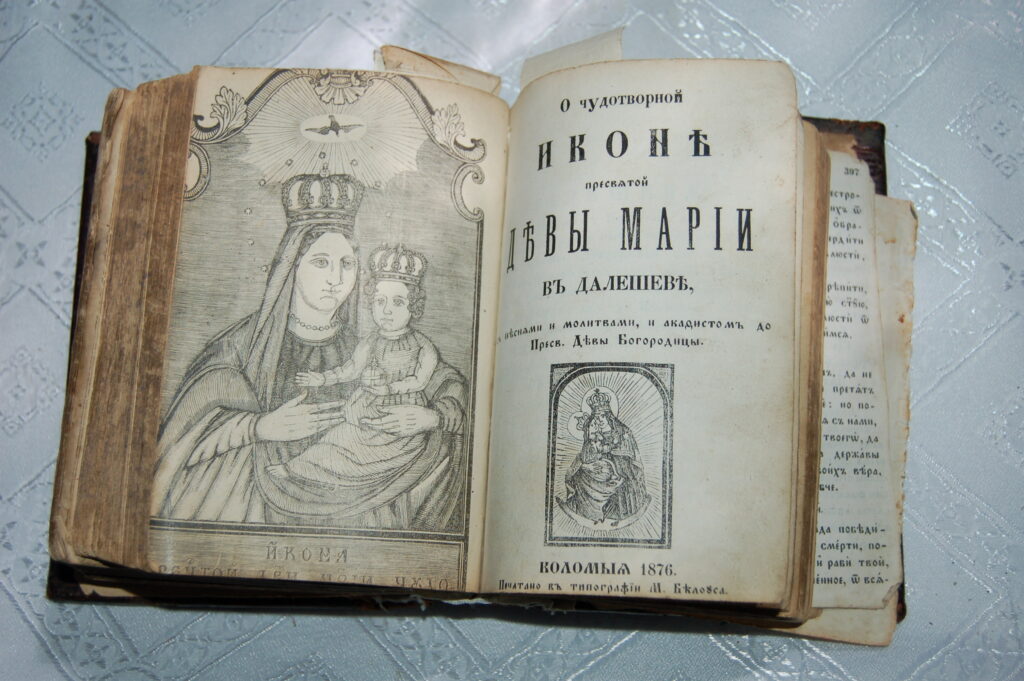 Стара книжка з іконою Богородиці і текстом.