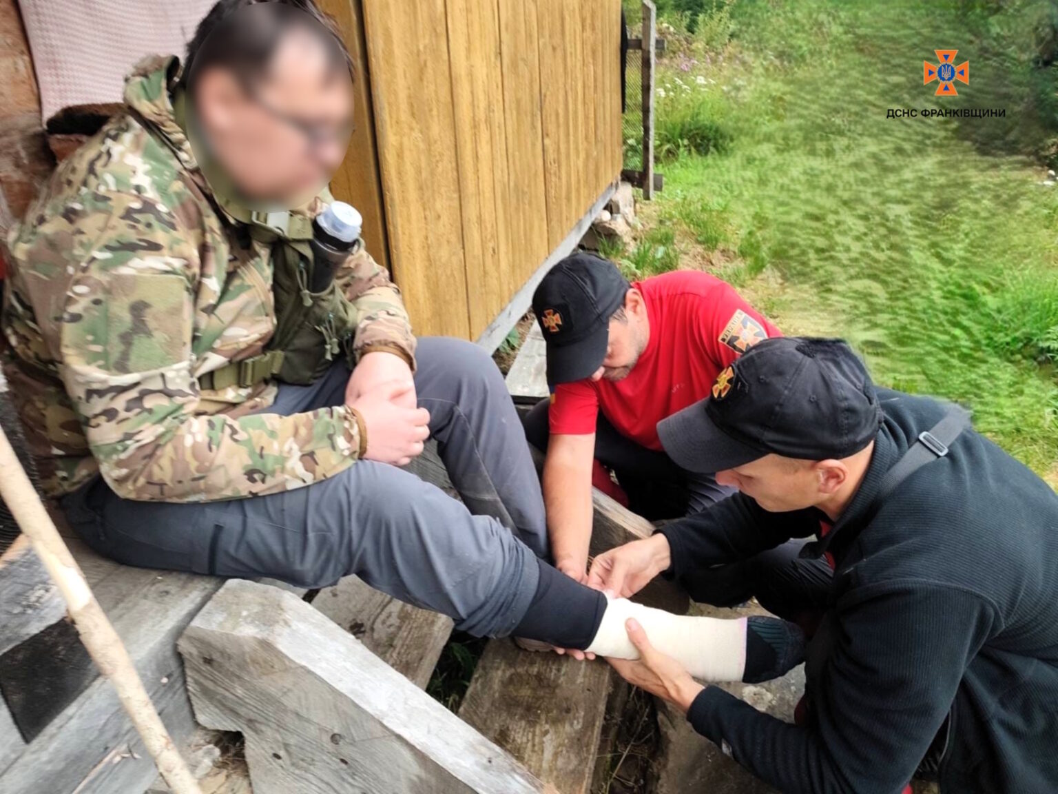 Рятувальники надають допомогу чоловіку з травмою ноги.